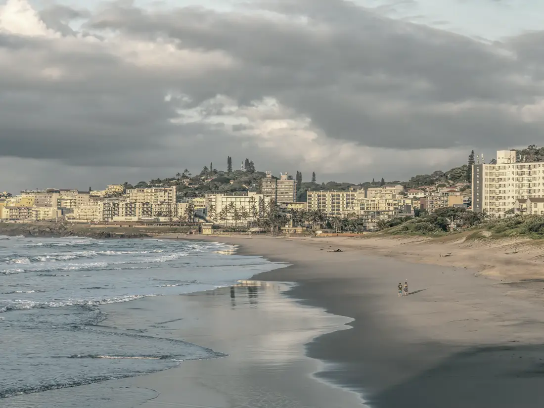 Ballito's main beach at golden hour, apartment blocks rising above the dune line